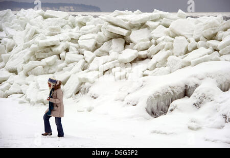 A woman trudges through a landscape of piled up sheets of ice on a beach along the Baltic Sea near Thiesseow, Germany, 10 February 2012. The recent strom in northern Germany has caused sheets of ice to pile up to meter high mountains of ice on the island of Ruegen. Meteorologists forecast more frosty temperatures to dominate the weather in the state of Mecklenburg-Western Pomerania Stock Photo