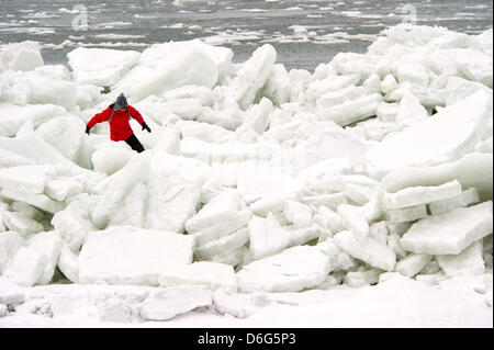 A woman climbes through a landscape of piled up sheets of ice on a beach along the Baltic Sea near Thiesseow, Germany, 10 February 2012. The recent strom in northern Germany has caused sheets of ice to pile up to meter high mountains of ice on the island of Ruegen. Meteorologists forecast more frosty temperatures to dominate the weather in the state of Mecklenburg-Western Pomerania Stock Photo