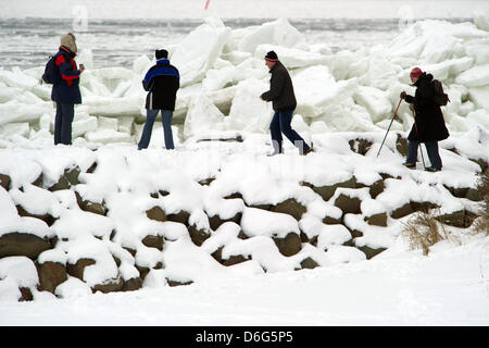 A group of tourists trudges through a bizzare landscape of piled up sheets of ice on a beach along the Baltic Sea near Thiesseow, Germany, 10 February 2012. The recent strom in northern Germany has caused sheets of ice to pile up to meter high mountains of ice on the island of Ruegen. Meteorologists forecast more frosty temperatures to dominate the weather in the state of Mecklenbu Stock Photo