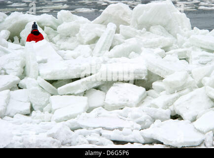 A woman climbes through a bizarre landscape of piled up sheets of ice on a beach along the Baltic Sea near Thiesseow, Germany, 10 February 2012. The recent strom in northern Germany has caused sheets of ice to pile up to meter high mountains of ice on the island of Ruegen. Meteorologists forecast more frosty temperatures to dominate the weather in the state of Mecklenburg-Western P Stock Photo