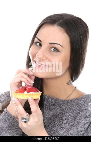 Happy Relaxed Young With Dark Hair Woman Holding And Eating a Fresh Strawberry Tart Snack Or Dessert Alone And Against A Plain White Background Stock Photo