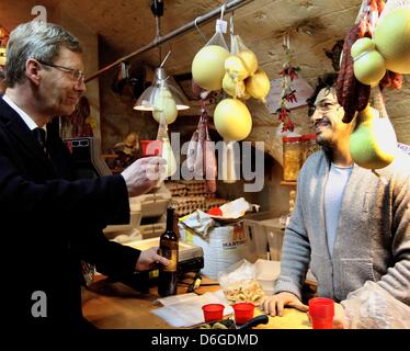 German President Christian Wulff visits a delicatessen shop and try specialties in Bari, Italy, 15 February 2012. The German President and his wife are on a three-day visit to Italy. Photo: WOLFGANG KUMM Stock Photo