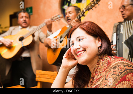 Hispanic woman in restaurant with traditional band Stock Photo