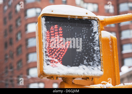 Walk sign on snowy city street Stock Photo