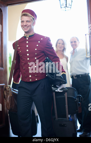 Bellhop carrying luggage in hotel Stock Photo