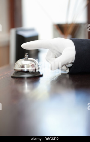 Bellhop ringing bell in hotel lobby Stock Photo
