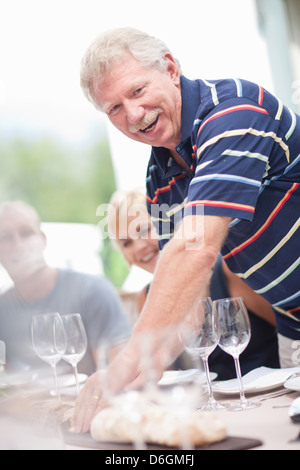 Man setting table outdoors Stock Photo