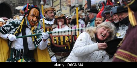 A so-called Federahannes, a fools character from Rottweil, jumps through the air during the traditional fools jump ('Narrensprung') in Rottweil, Germany, 20 February 2012. The fools jump is one of the most traditional parades of the Swabian-Alemannic carnival. Photo: PATRICK SEEEGR Stock Photo