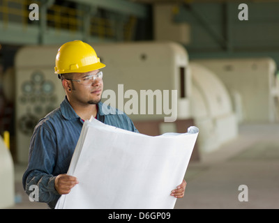 Engineer reading blueprints on site Stock Photo