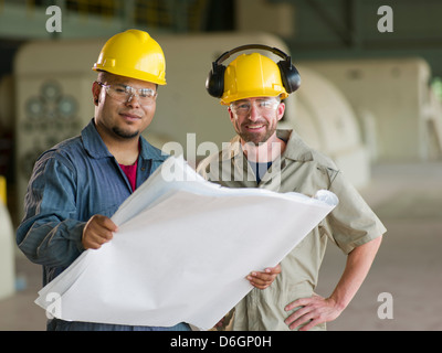 Engineers reading blueprints on site Stock Photo