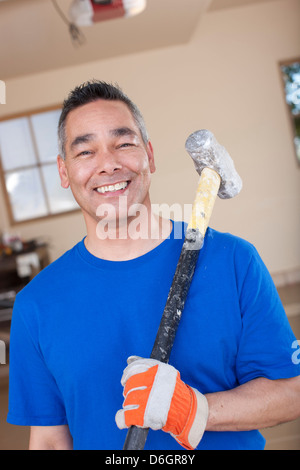 Man holding sledge hammer in garage Stock Photo