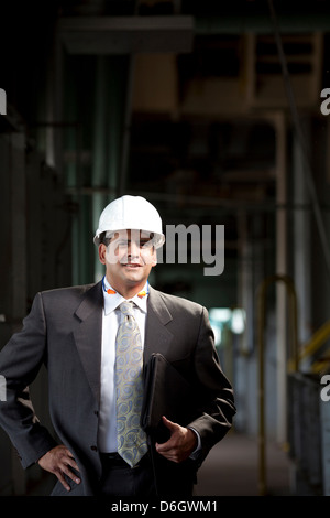 Businessman carrying folder in plant Stock Photo