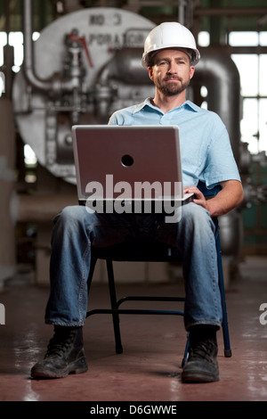 Industrial worker using laptop Stock Photo