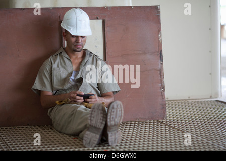 Industrial worker using cell phone Stock Photo