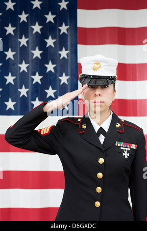 Servicewoman in dress blues by US flag Stock Photo