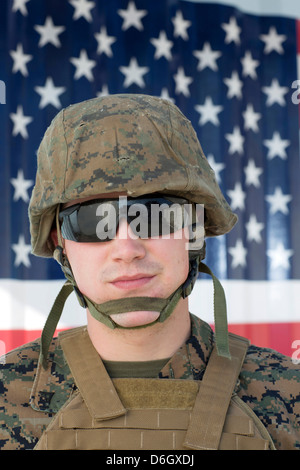Serviceman in camouflage by US flag Stock Photo