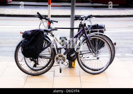 Bikes chained to post in city street Stock Photo