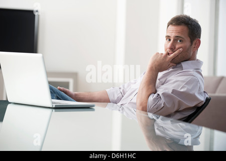 Businessman using laptop at desk Stock Photo