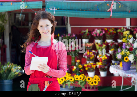 Florist making notes in shop Stock Photo
