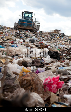 Truck moving garbage in a landfill site Stock Photo