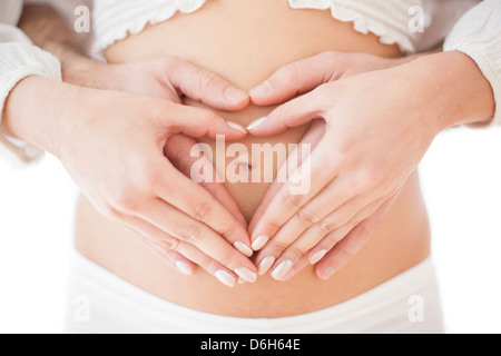 Couple holding pregnant woman's abdomen Stock Photo