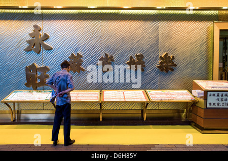 Hong Kong, a man looking at the menu on a restaurant entrance in Langham Place Stock Photo