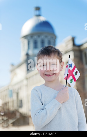 Boy waving a flag of Montreal in front of Marché Bonsecours Market in Old Montreal Stock Photo