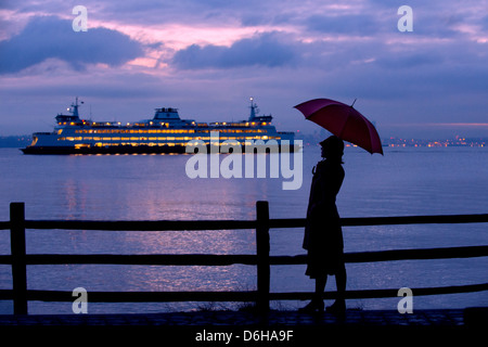 Woman with umbrella admiring cruise ship