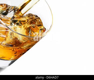 Whiskey over ice pouring into glass Stock Photo