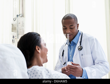 Doctor talking to patient in hospital, looking at medicine Stock Photo