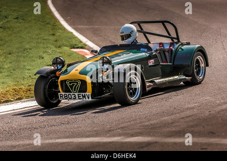 Front and side view of a green and yellow Caterham Seven car racing at Cadwell park race track. Stock Photo