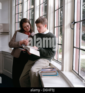 Teacher and high school student review a textbook. Stock Photo