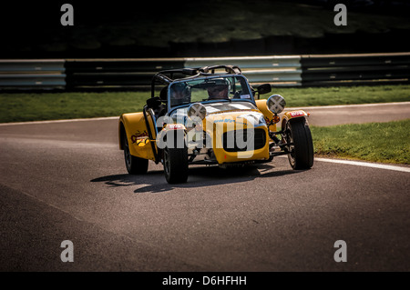Yellow Caterham Seven car racing at Cadwell park race track. Stock Photo