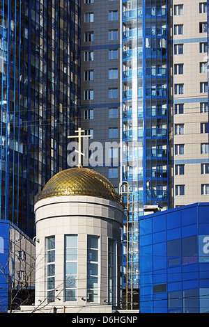 The new multi-storey residential building, constructed together with the Orthodox Church Stock Photo