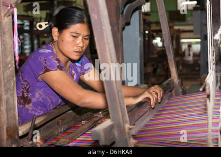 Woman weaving on a loom, Thein Nyo silk weaving workshop, Amarapura, Mandalay, Myanmar, (Burma) Stock Photo