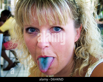 Lady woman sticking out tongue and tongue is blue Stock Photo