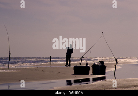 A surf fisherman fighting a fish from the beach on Matagorda Island Texas Stock Photo
