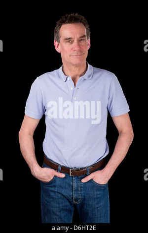 Happy Smiling Middle Age Man with Hands in Pockets Relaxed Black Background Stock Photo