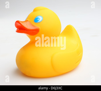 Yellow rubber Duck with blue eyes and orange beak on white background side view