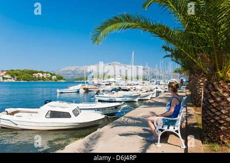 Tourist sitting in Lumbarda Harbor, Korcula Island, Dalmatian Coast, Adriatic, Croatia, Europe Stock Photo