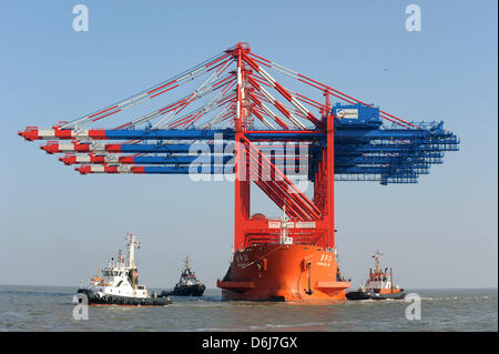 A cargo vessel loaded with giant gantry cranes arrives at the pier of the JadeWeserPort in Wilhelmshaven, Germany, 6 March 2012. Four new new gantry cranes have finally arrived after being shipped for two months aboard the 245 metre-long 'Zhenhua 23' from China. The cranes are destined for the Eurogate Container Terminal, the new deep water harbour. The cranes mark the first arriva Stock Photo