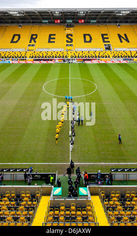 The teams of Dynamo Dresden and FC Ingolstadt walk to the pitch surrounded by an empty stadium during the 2nd Bundesliga match between the two teams at Gluecksgas-Stadium in Dresden, Germany, 11 March 2012. The German Football Association punished Dynamo Dresden with a ghost game and 100 000euro money fine, after several riots of fans that happened after soccer games. Photo: Oliver Stock Photo