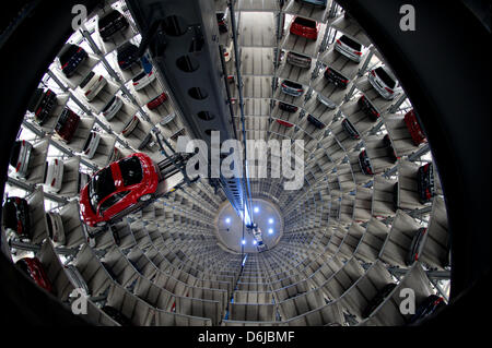 A Volkswagen up! and a red Beetle float to vacant lots inside the sales tower of the VW Autostadt in Wolfsburg, Germany, 12 March 2012. Volkswagen has achieved its best balance in the company's history. Photo: Daniel Reinhardt Stock Photo