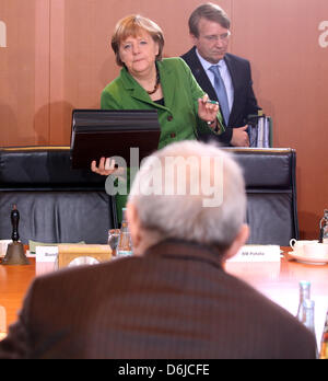 German Chancellor Angela Merkel (CDU) takes her seat next to German Minister for Special Affairs Ronald Pofalla (CDU, R) at the start of the cabinet meeting at the Federal Chancellery in Berlin, Germany, 14 March 2012. Across from the chancellor sits German Minister of Finance Wolfgang Schaeuble (CDU). The cabinet will pass the euro aid package ESN. Photo: WOLFGANG KUMM Stock Photo