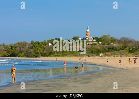 Walkers and the Nosara Beach Hotel at popular Playa Guiones beach, Nosara, Nicoya Peninsula, Guanacaste Province, Costa Rica Stock Photo