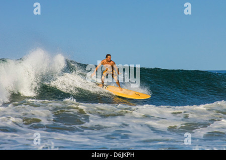 Surfer on longboard riding wave at popular Playa Guiones surf beach, Nosara, Nicoya Peninsula, Guanacaste Province, Costa Rica Stock Photo