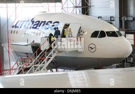 Technicians work on an Airbus A340 at a Jumbo maintenance hall of Lufthansa Technik AG in Hamburg, Germany, 22 March 2012. Lufthansa Technik suffers from increasing competition and lower prices. Photo: Christian Charisius Stock Photo