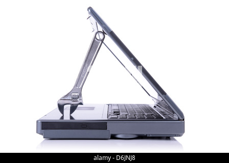 concept of it support with a spanner holding open a laptop isolated on white background Stock Photo