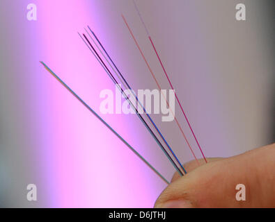 A man holds a fiber optic cables during a press conference about the cooperation between Telekom and housing authority Annington in Bochum, Germany, 26 March 2012. Within the next years Annington housholds are to be connected to the fiber optic network. Photo: CAROLINE SEIDEL Stock Photo