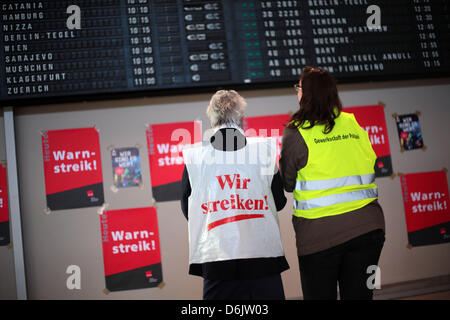 Striking airport employees stand in front of the departure board during a warning strike at Cologne/Bonn airport in Cologne, Germany, 27 March 2012. Verdi has called on ground control employees to down tools to apply pressure on their employers over ongoing wage negotiations. Photo: OLIVER BERG Stock Photo